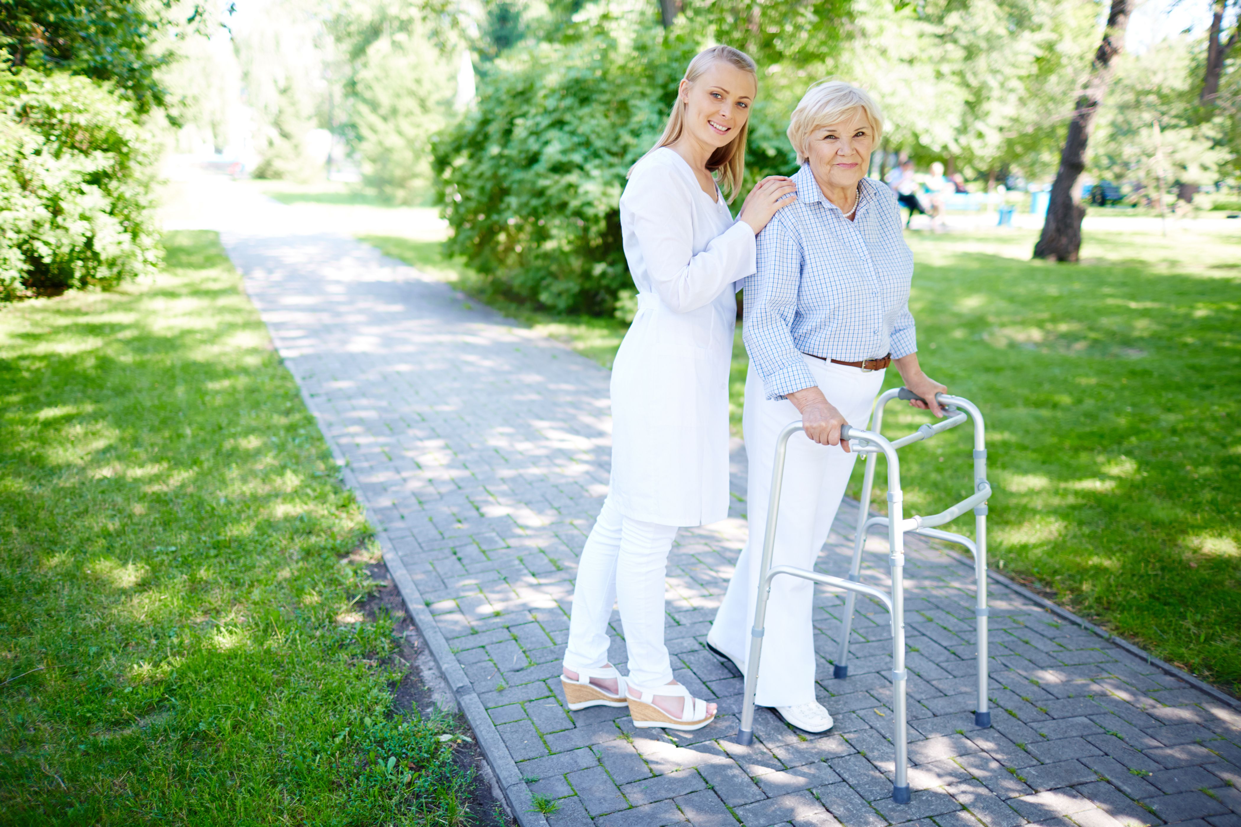 Pretty personal care nurse walking out with senior client